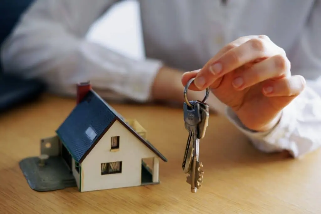 Casa e chave sendo entregue, simbolizando onde comprar fundos imobiliários