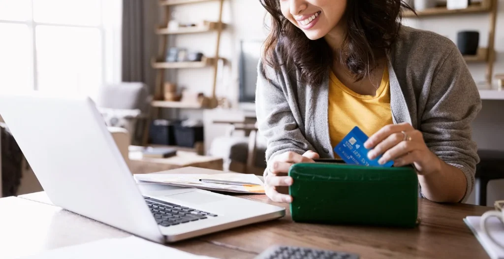 Mulher segurando cartão da visa, fazendo referência a comprar ações da visa.